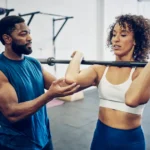 A personal friendly trainer assisting with fitness exercises
