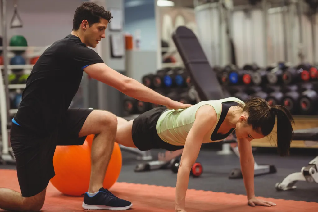 Friendly personal trainers focus on guiding clients to maintain proper form and technique